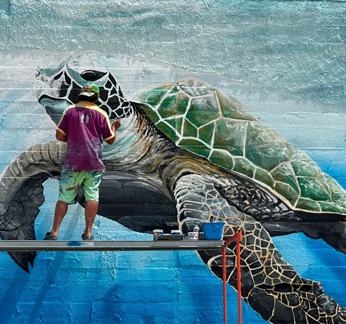 Rémi Bertoche peignant une fresque monumentale de tortue marine