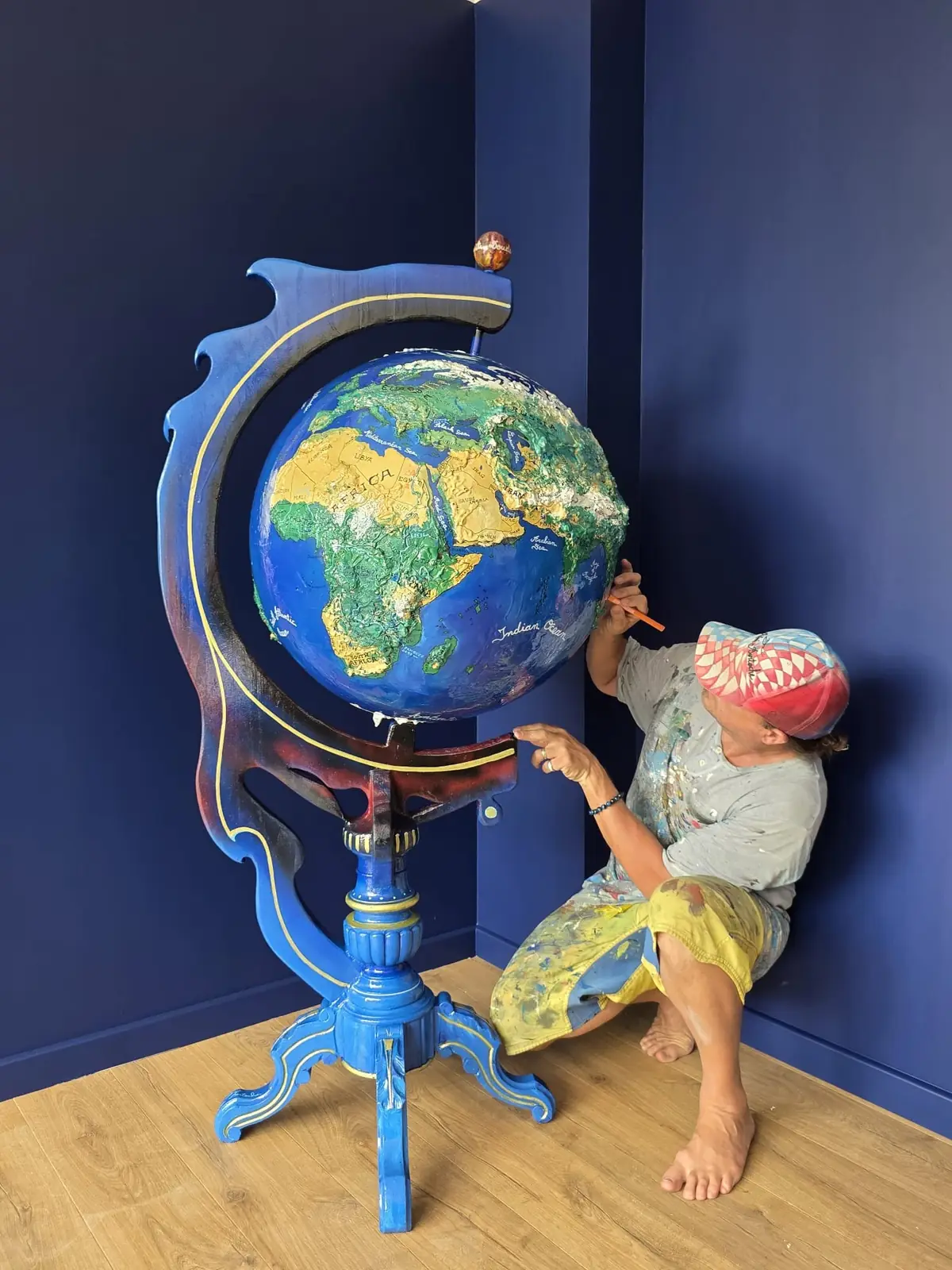 Rémi Bertoche hand-painting a monumental globe in his studio